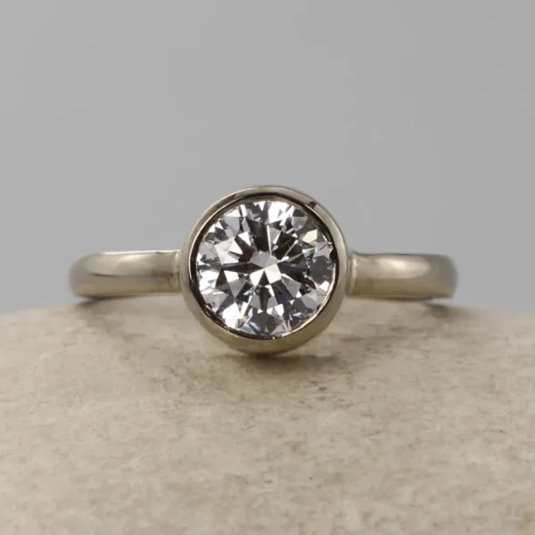 The Aise: 14ct White Gold Round Diamond Solitaire Bezel Set Engagement Ring